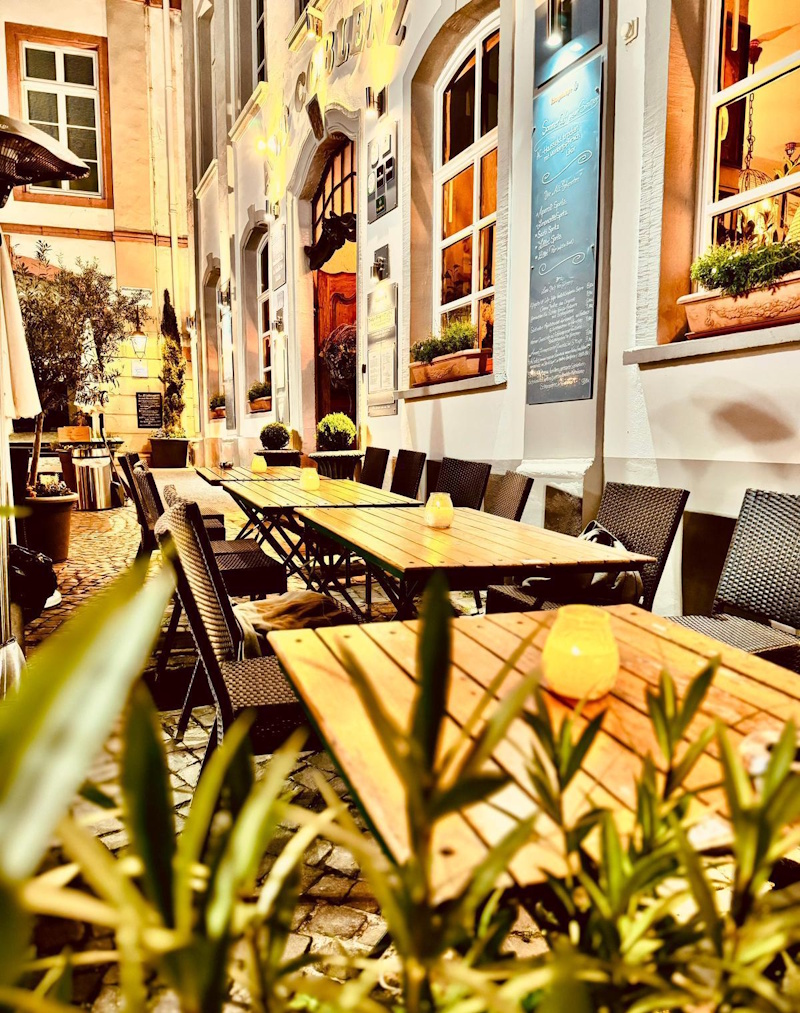 Terrasse des Alt Coblenz mit Holztischen in einer Gasse der Koblenzer Altstadt