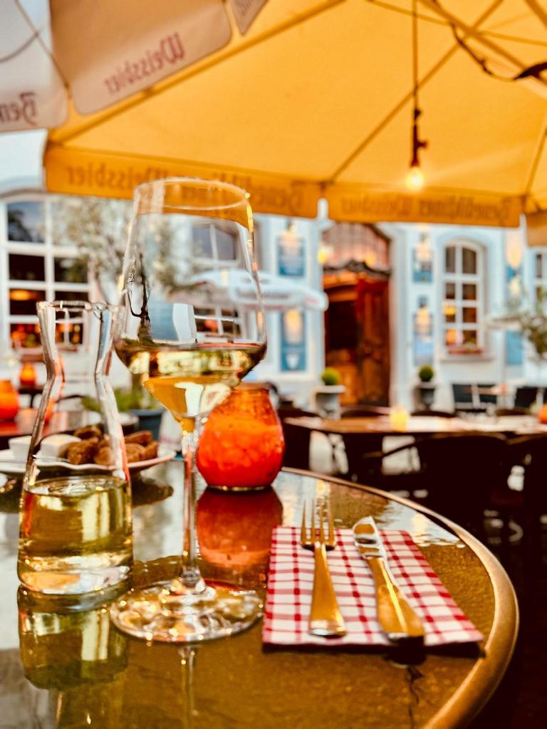 Glas Weißwein und Aperitif auf einem Tisch im Alt Coblenz am Abend Glas Weißwein und Aperitif auf einem Tisch im Alt Coblenz am Abend